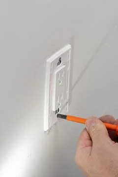 Preparing to install an electrical outlet, checking the fastening of the scre Stock Photos