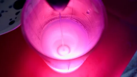 Preparing a iridescent fluorescent pink neon cocktail using an immersion whisk Stockbeeldmateriaal 105081581