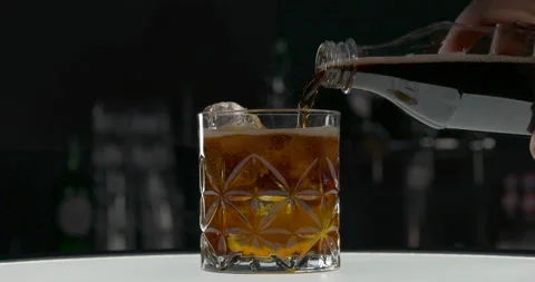 Preparing jack and coke cocktail. Unrecognizable bartender mixing whiskey with Stock Footage 148322455