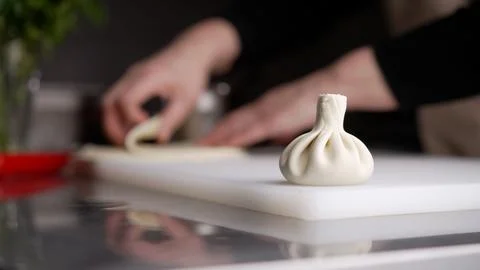 Preparing khinkali dumpling by hand in kitchen Stock Photos