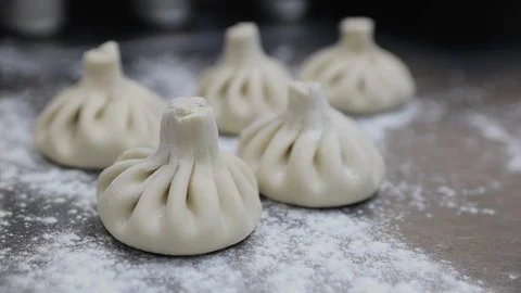 Preparing of khinkali in georgian kitchen by traditional recipe. Raw dumplings Stock Footage 128661099