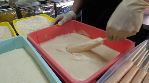 Preparing Korean Corn Dogs Twisting Skewered Sausage in Thick Elastic Dough Batt Video stock 343587668