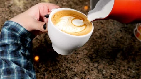 Preparing a latte coffee in the cafe. delicious hot beverages in a white cup. 動画素材 334648580