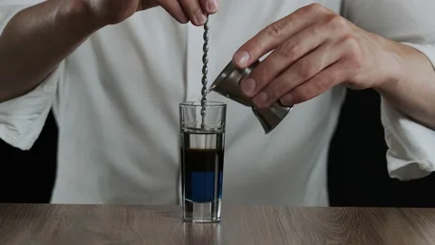 Preparing of Lexus Cocktail. Bartender pouring irish cream into glass Stock Footage 133933699