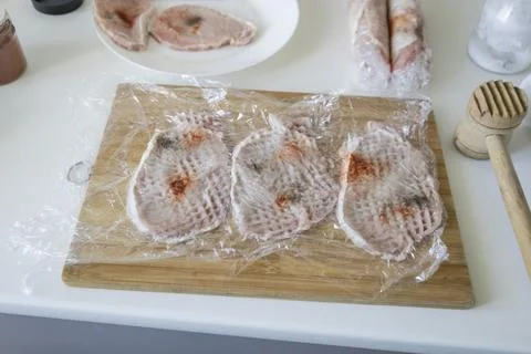 Preparing meat for chops. A raw pork chops, cut into pieces and sprinkled w.. Stock Photos