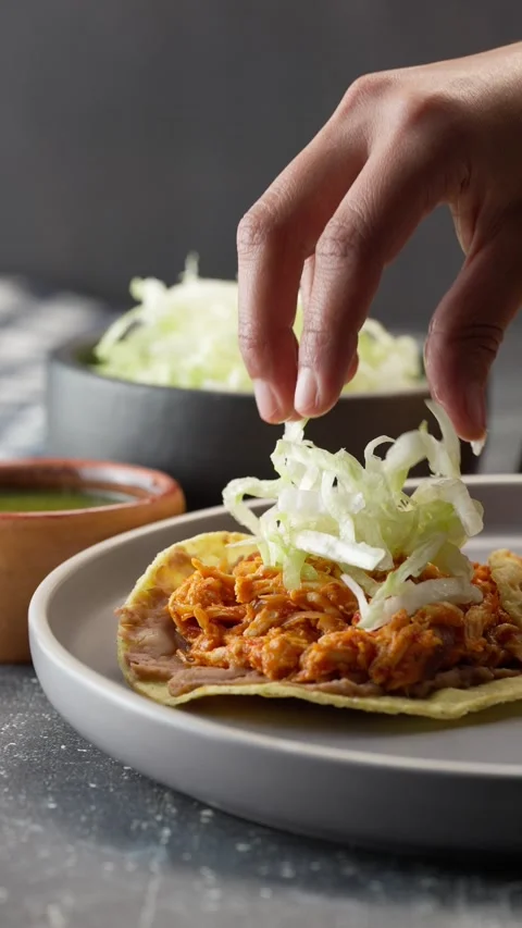 Preparing mexican chicken tinga tostadas with lettuce, vertical video Stock Footage 282549057