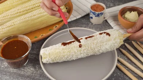 Preparing Mexican corn, Adding homemade red sauce Stock Footage 280316819