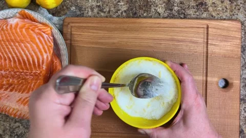 Preparing a mixture for salting salmon fish from salt, sugar and lemon zest. Vidéo 300453073