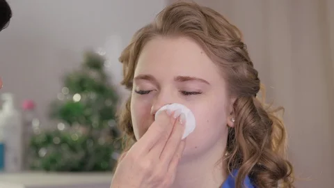 Preparing the model's skin for applying makeup. Treatment of the face with a Stock Footage 122943425