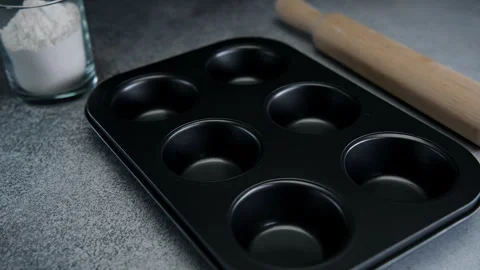 Preparing a Muffin Pan for Baking in a Home Kitchen During the Day Stock Footage 273700640