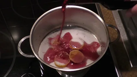 Preparing mulled wine. Lemon slices in a pot, add sugar and red wine, cook Stock Footage 76805250