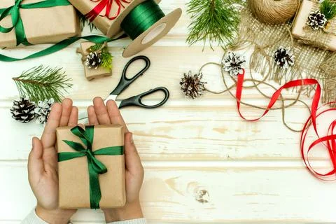 Preparing for the new year. Making handmade gifts. Hands packing a gift Stock Photos