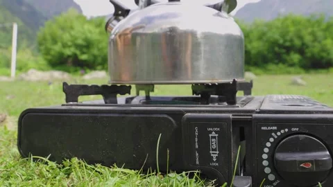 Preparing outdoor camping stove for kettle use on grass Stock Footage 301401885