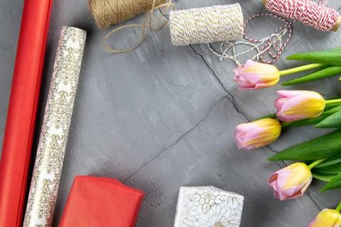 Preparing for the packaging of gifts, on the table laid out red and white wra Stock Photos