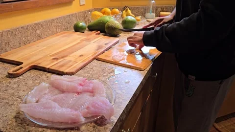 Preparing Parrot Fish Fillets in a Warm Kitchen Setting with Fresh Ingredients Stock Footage 296263999