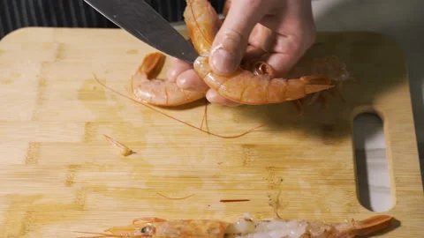 Preparing to peal off and clean fresh shrimp shells for cooking Stock Footage 104537390