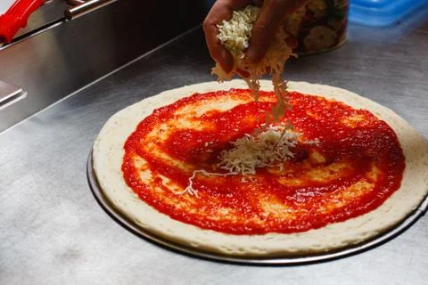 Preparing the pizza base. Applying cheese slices Stock Photos