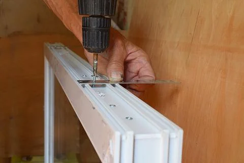 Preparing a plastic window for installation in a window opening. Stock Photos