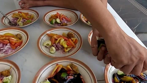 Preparing plates of colorful vegetable salad. Satay seasoning. Stock Footage 279342008