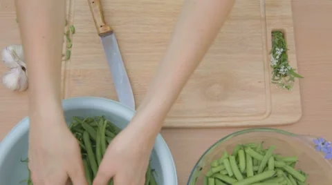 Preparing pods of fresh green beans for further chopping outdoors Stock Footage 8367431