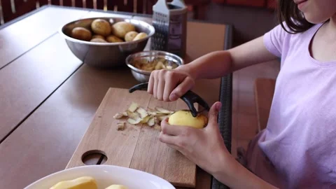 Preparing potatoes for cooking in a cozy kitchen setting Stock Footage 297358637