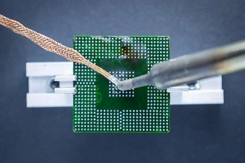 Preparing the processor before reballing. Removing excess tin from the comput Foto stock