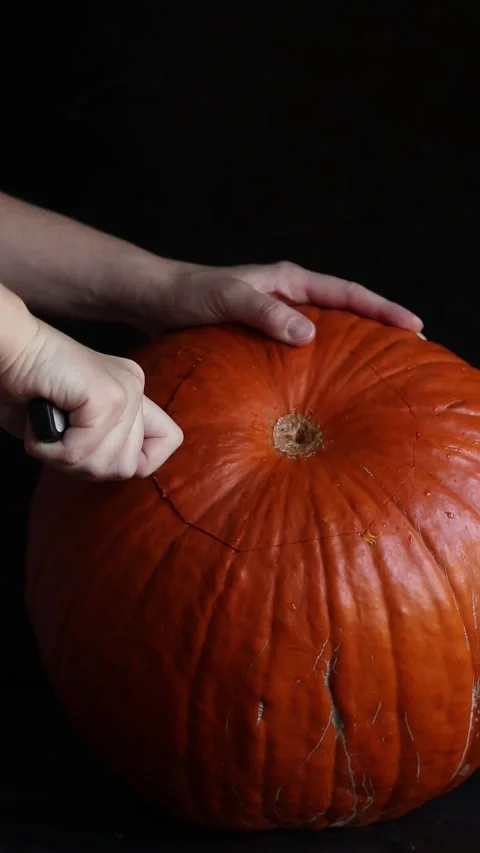 Preparing a pumpkin for Halloween or culinary processing with a knife Video stock 347613085