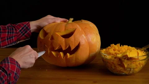 Preparing pumpkin for Halloween. Scooping out guts and seeds with spoon. Woma Stock Footage 272460108
