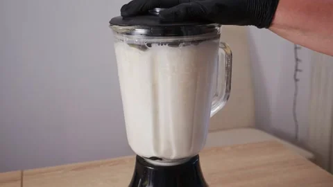 Preparing raw blanched almonds with water in glass blender. Stock Footage 344886116