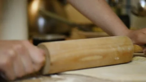 Preparing raw flour dough with rolling pin on table Stock Footage 340078101