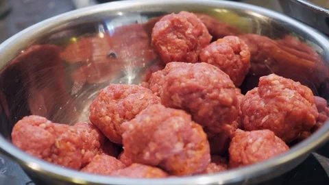Preparing raw meat balls drop into metal bowl Stock Footage 111926179