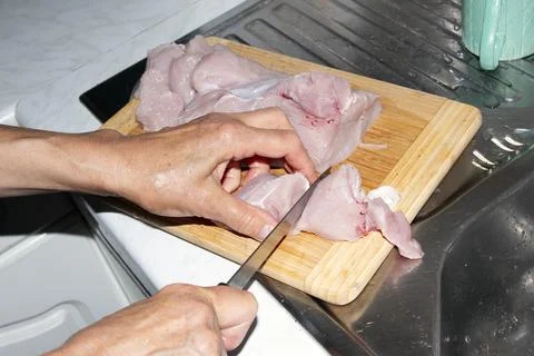 Preparing Raw Poultry Pieces with Knife on Cutting Board Stock Photos