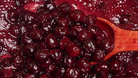 Preparing red cherries with sugar to make cherry jam in saucepan with spoon Stock Footage 320598980