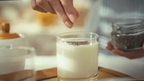 Preparing a refreshing drink with chia seeds and milk in a cozy kitchen sett Stock Footage 323656673