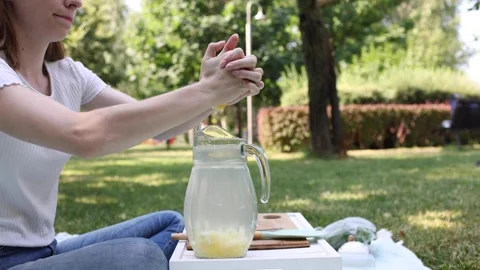Preparing a refreshing drink in a sunny park on a warm day Stock Footage 297370210
