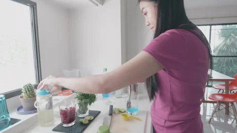 Preparing Refreshing Herbal Drinks in a Bright Kitchen Setting Stock Footage 313918435