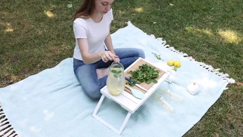 Preparing refreshing lemonade with fresh lemons and mint in the park Stock Footage 297370243