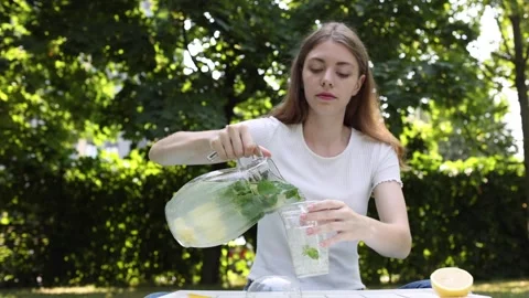 Preparing refreshing lemonade outdoors on a sunny day with fresh ingredients Stock Footage 297361542