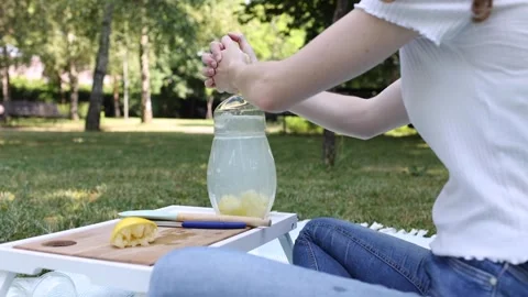 Preparing refreshing lemonade in a sunny park on a warm afternoon Stock Footage 297370208