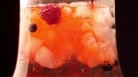 Preparing a refreshing summer drink with ice and berries. Drops of syrup in the Video stock 149898451