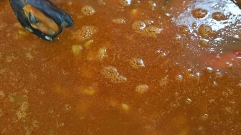 Preparing a rich paella, adding mussels Stock Footage 219717467