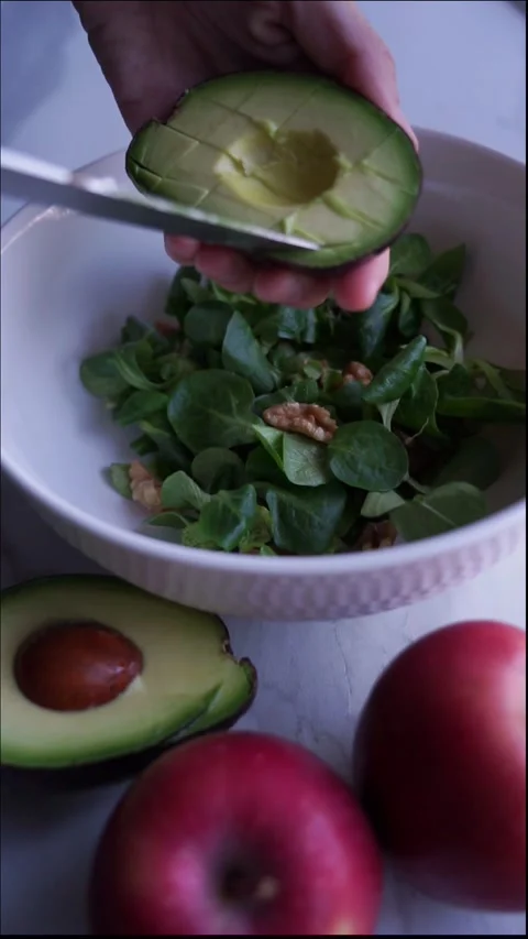 Preparing a salad by cutting avocado Stock Footage 256788288