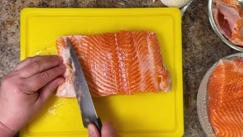 Preparing salmon fish fillets with a knife for further cooking. Top view. Stock Footage 300457400