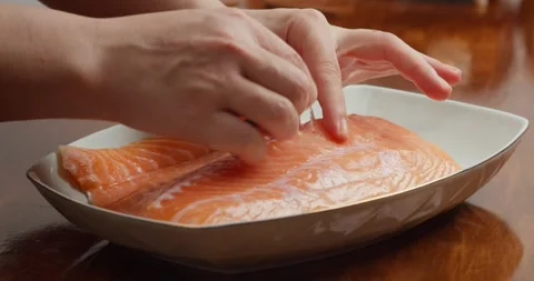 Preparing the salmon: Remove the bones from the fillet with a piercer. Season Vídeos de archivo 327146207