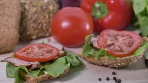 Preparing sandwich on breakfast table full of vegtables.  Video stock 138387137