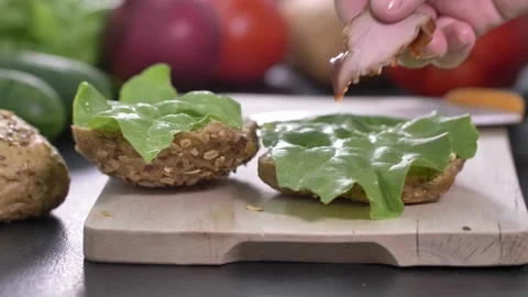 Preparing sandwich on breakfast table full of vegtables.  Stock-Footage 138387253