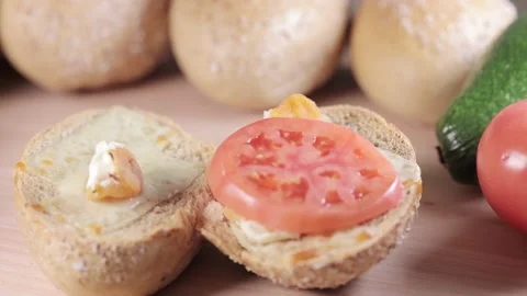 Preparing sandwich on breakfast table full of vegtables.  Vídeos de archivo 154459461