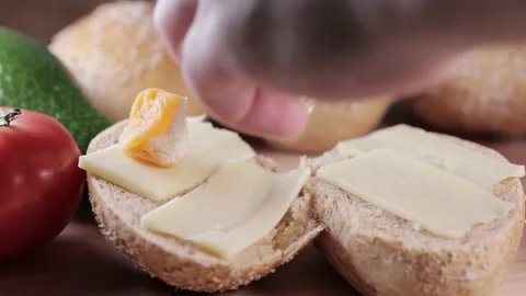 Preparing sandwich on breakfast table full of vegtables.  Vídeos de archivo 154459748