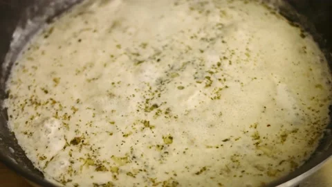 Preparing the sauce for oven roasted chicken. Sauce boiling in a frying pan Stock Footage 151430336