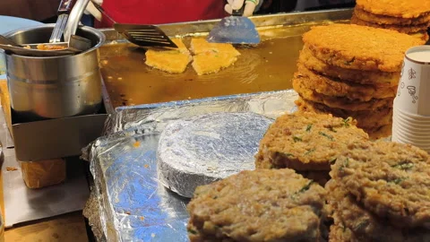 Preparing savory Korean snacks on hot griddle. Stacked pancakes show delicious Stock Footage 325422037